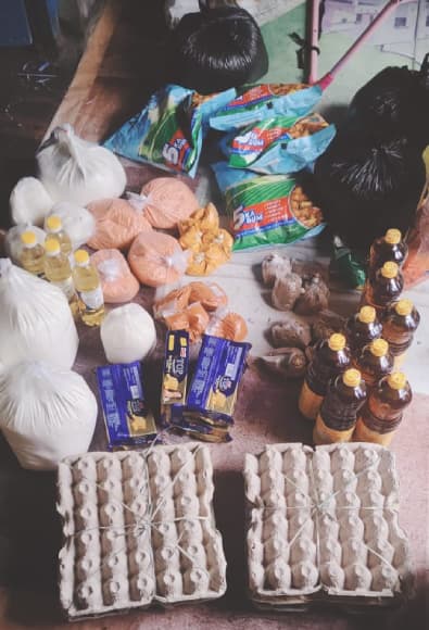 A family in their home with the monthly ration supplies we delivered